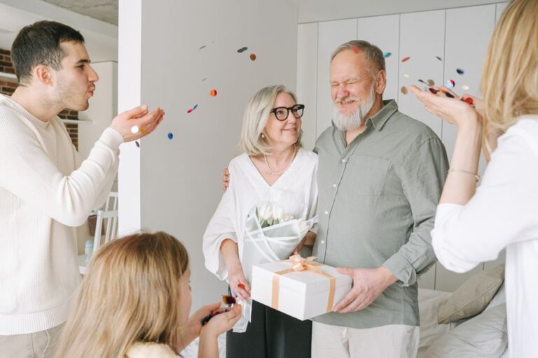 Cadeau utile pour senior de 80 ans : 10 idées qui changent le quotidien - Happy elderly couple receives gifts and love from family during an indoor celebration.