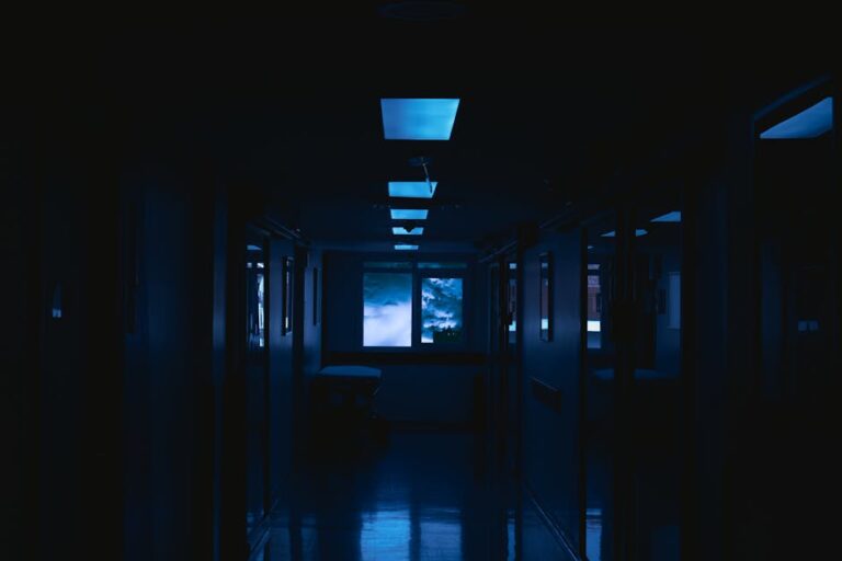 Veilleuse détecteur de mouvement senior : guide nuit 2026 - A mysterious dark corridor with eerie glowing lights and an illuminated window view.